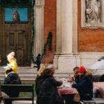 a group of people sitting at a table in front of a building